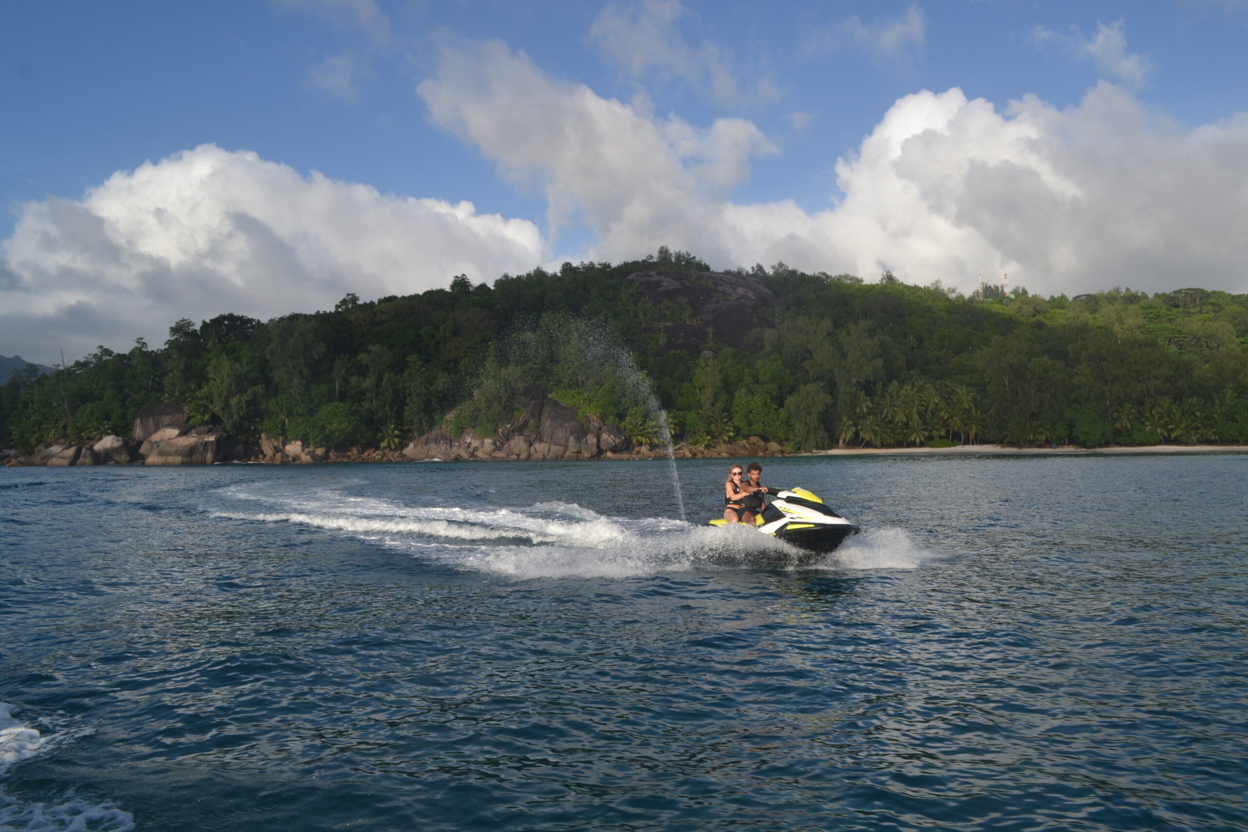 un couple de jeunes sur un jetski profitant du forfait 45 min où ils longent la côte ouest au sud de Mahé aux Seychelles